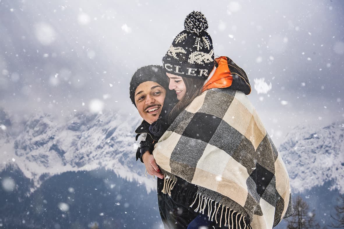coppia neve montagna abbraccio sorrisi